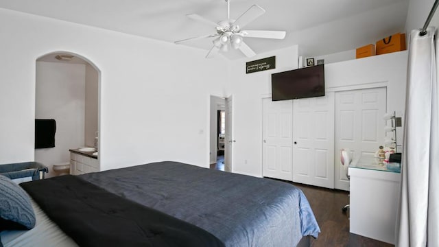 bedroom featuring ceiling fan, dark hardwood / wood-style flooring, ensuite bathroom, and a closet