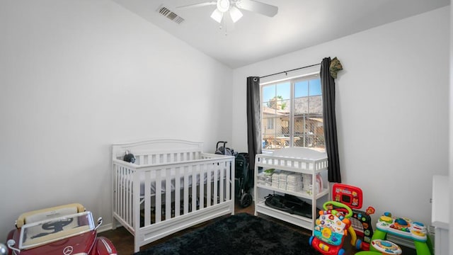 bedroom featuring a crib, ceiling fan, and lofted ceiling