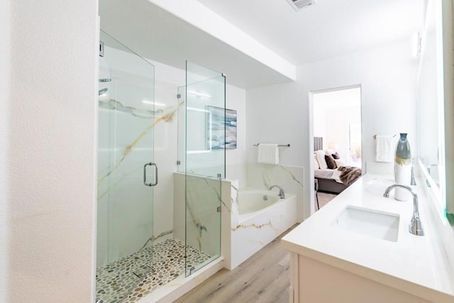 bathroom with wood-type flooring, separate shower and tub, and vanity