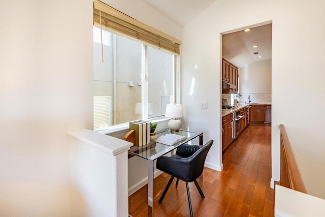 dining room featuring sink, vaulted ceiling, and dark hardwood / wood-style floors