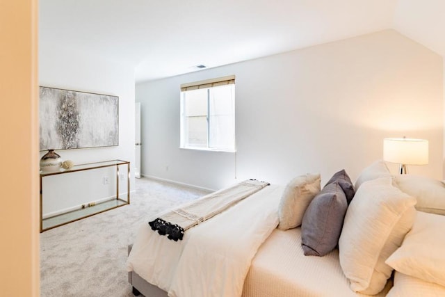 bedroom with vaulted ceiling and light colored carpet