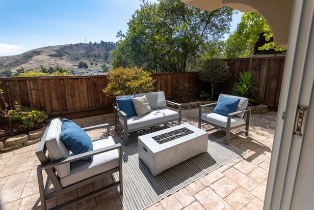 view of patio featuring a mountain view and an outdoor living space with a fire pit