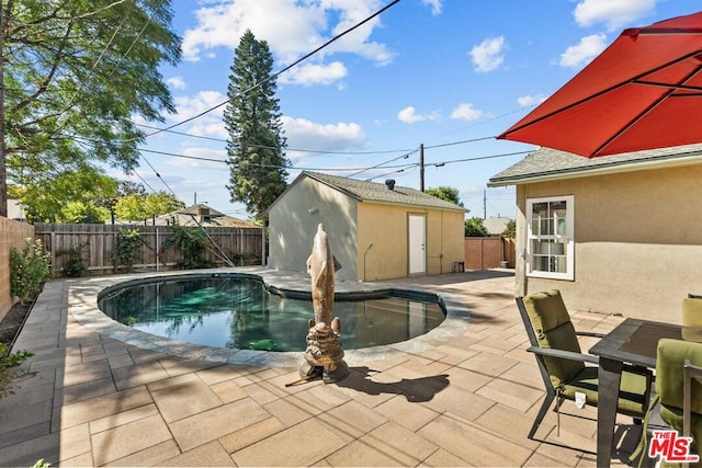 view of swimming pool with a patio area and an outdoor structure