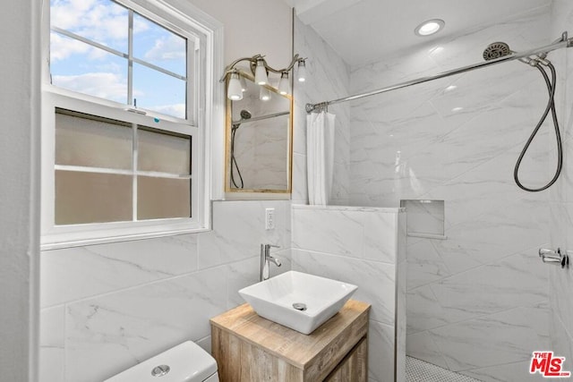 bathroom with tile walls, toilet, walk in shower, and vanity