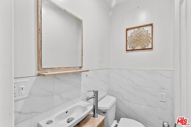 bathroom with toilet, tile walls, and vanity