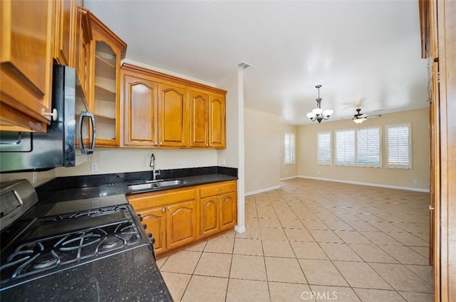 kitchen with sink, decorative light fixtures, light tile patterned floors, black appliances, and ceiling fan with notable chandelier