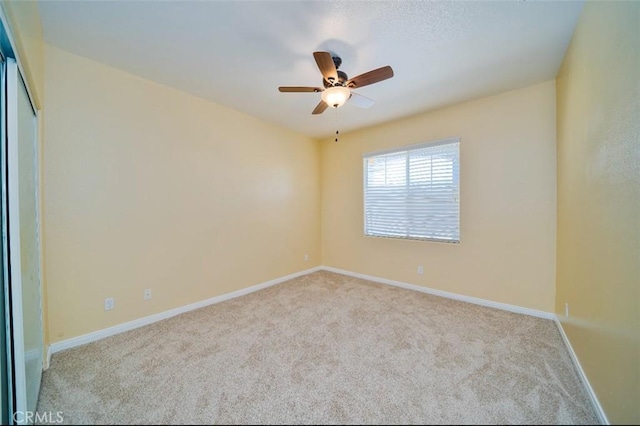 empty room with ceiling fan and light colored carpet