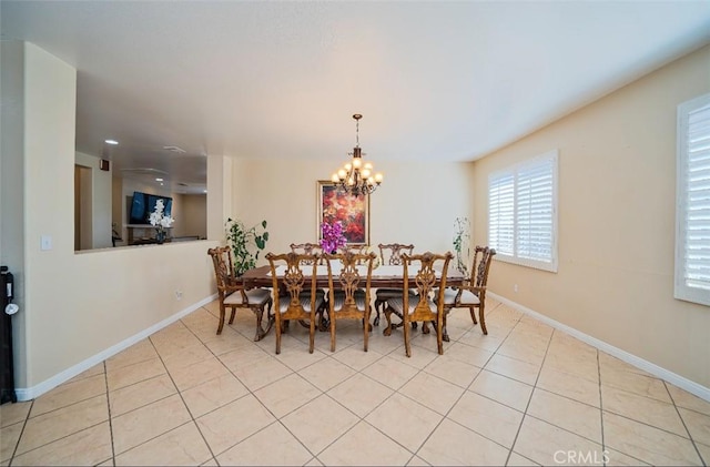 tiled dining room featuring a chandelier