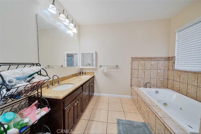 bathroom with tile patterned floors, vanity, and tiled bath