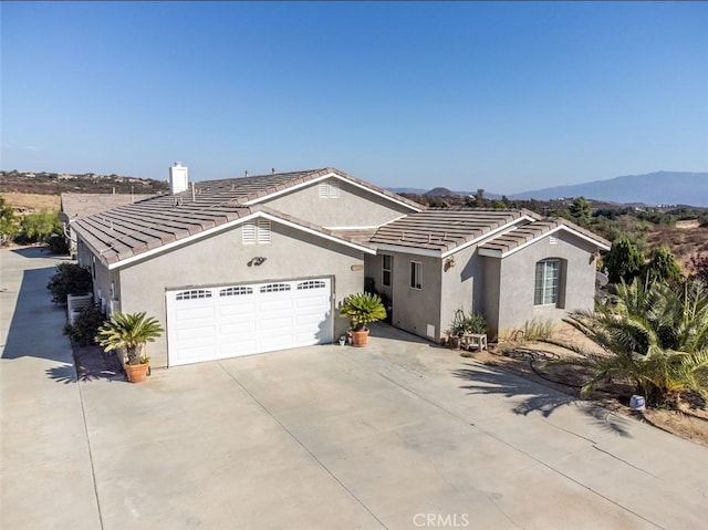 single story home featuring a mountain view and a garage