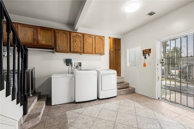 laundry room featuring separate washer and dryer, cabinets, and light tile patterned floors