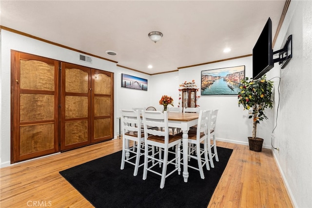 dining space featuring light hardwood / wood-style flooring and ornamental molding