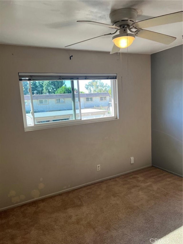 empty room featuring carpet floors and ceiling fan