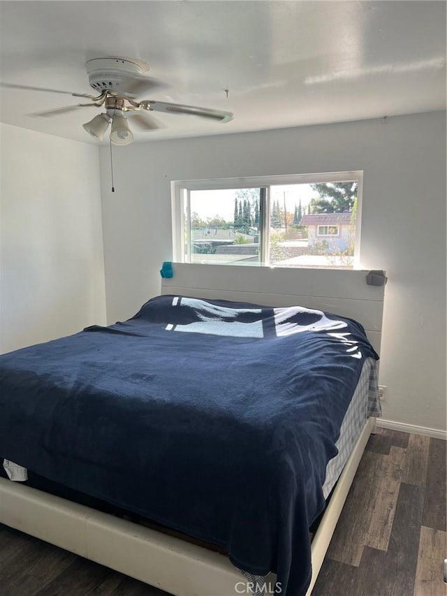 bedroom with multiple windows, ceiling fan, and dark hardwood / wood-style floors