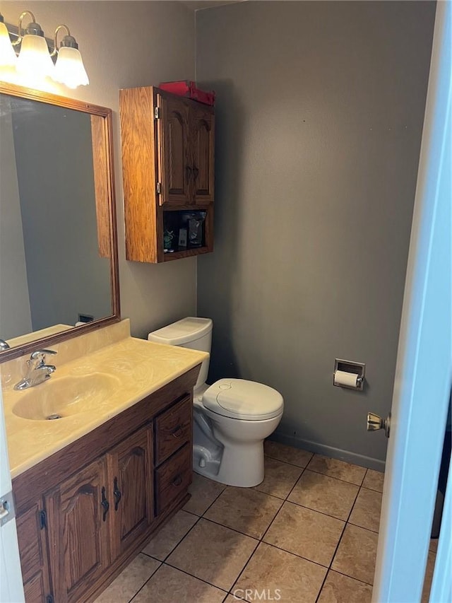 bathroom featuring tile patterned flooring, vanity, and toilet