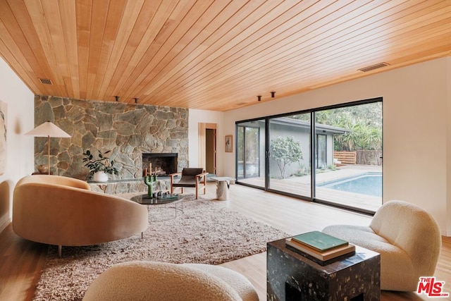 living room featuring hardwood / wood-style flooring, wooden ceiling, and a fireplace