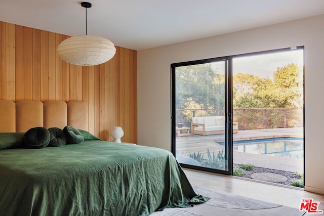 bedroom featuring access to outside and wooden walls