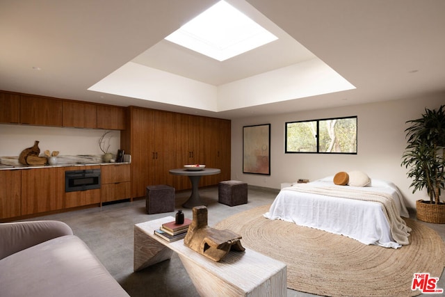 bedroom with a raised ceiling and a skylight