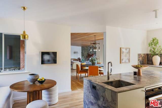 kitchen featuring sink, wooden ceiling, hanging light fixtures, light hardwood / wood-style flooring, and a notable chandelier