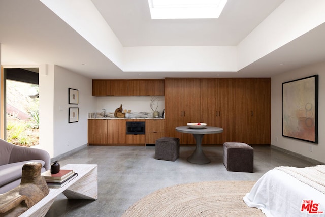 bedroom with a tray ceiling and a skylight