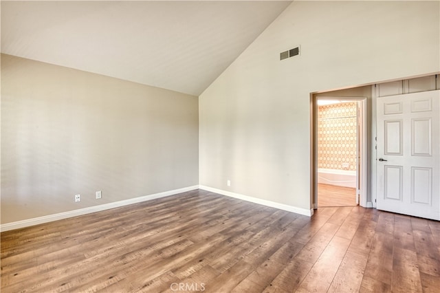 unfurnished bedroom with high vaulted ceiling and hardwood / wood-style floors