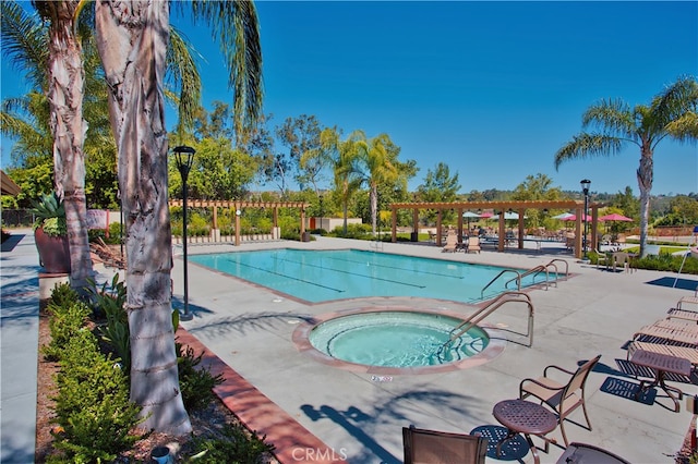 view of swimming pool featuring a patio and a community hot tub