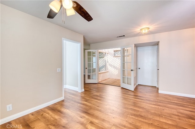 unfurnished room featuring french doors, light hardwood / wood-style flooring, and ceiling fan