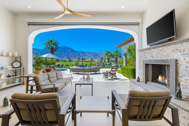 view of patio featuring an outdoor living space with a fireplace and ceiling fan