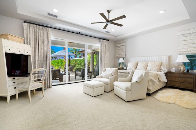 carpeted bedroom with access to outside, a raised ceiling, and ceiling fan