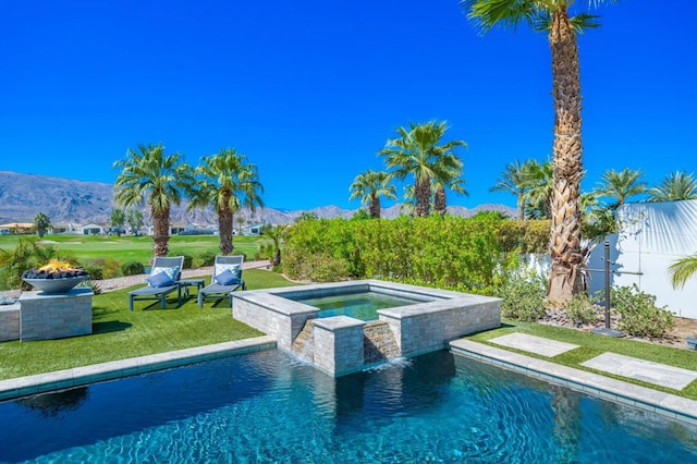 view of swimming pool with an in ground hot tub, a mountain view, a yard, and pool water feature