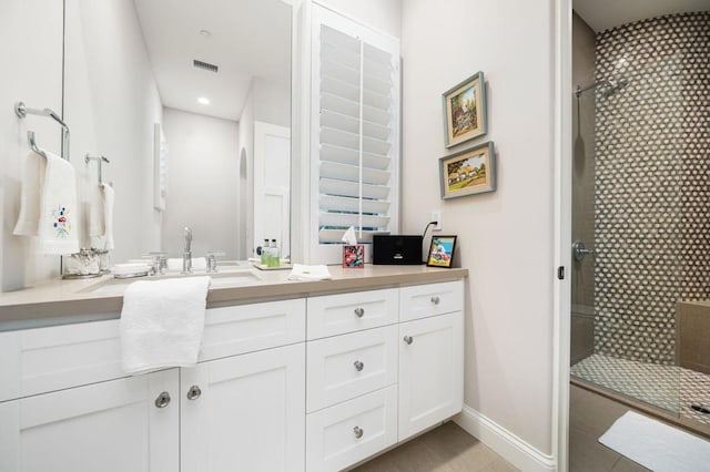 bathroom featuring a tile shower, vanity, and tile patterned floors