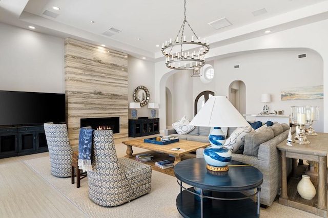 living room with a large fireplace and a notable chandelier