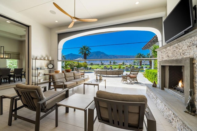 view of patio featuring an outdoor living space with a fireplace and ceiling fan