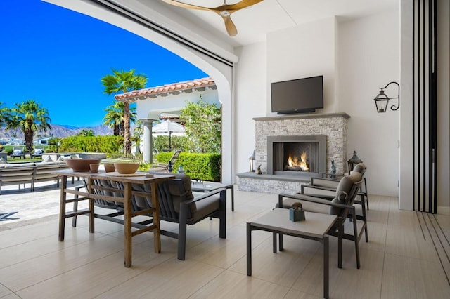 view of patio / terrace with a mountain view, an outdoor stone fireplace, and ceiling fan