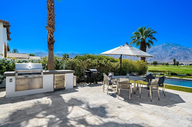 view of patio / terrace with an outdoor kitchen, area for grilling, and a mountain view