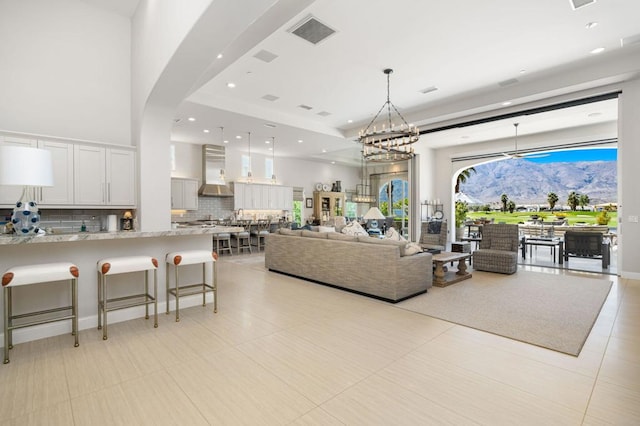 living room featuring a notable chandelier and light tile patterned flooring