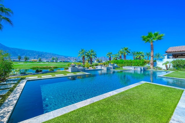 view of pool featuring a mountain view and a yard