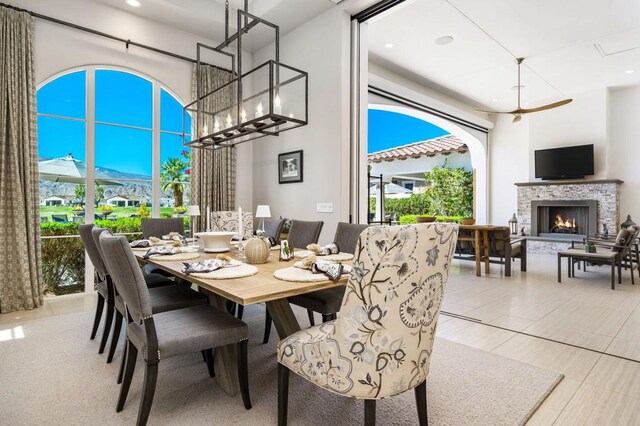 dining space featuring a stone fireplace and plenty of natural light