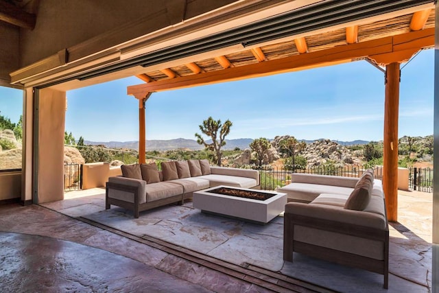 view of patio / terrace with a mountain view and an outdoor living space with a fire pit