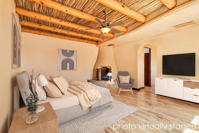 bedroom featuring beam ceiling and light hardwood / wood-style floors