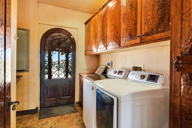 clothes washing area featuring washer and clothes dryer and cabinets