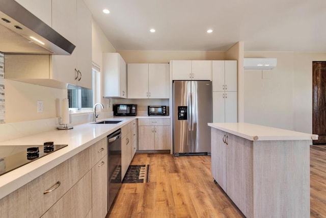 kitchen with black appliances, an AC wall unit, sink, light hardwood / wood-style flooring, and range hood