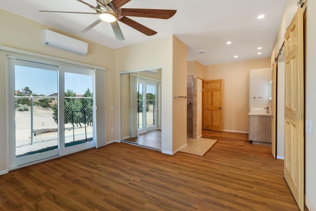 entryway with a wall mounted AC, ceiling fan, dark hardwood / wood-style flooring, and a barn door