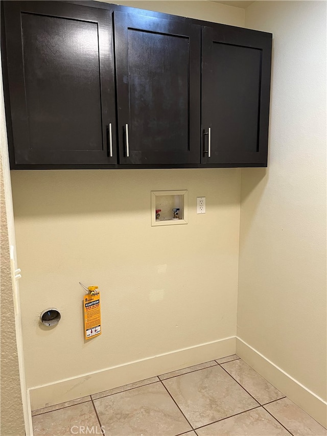 laundry room with washer hookup, cabinets, and light tile patterned flooring