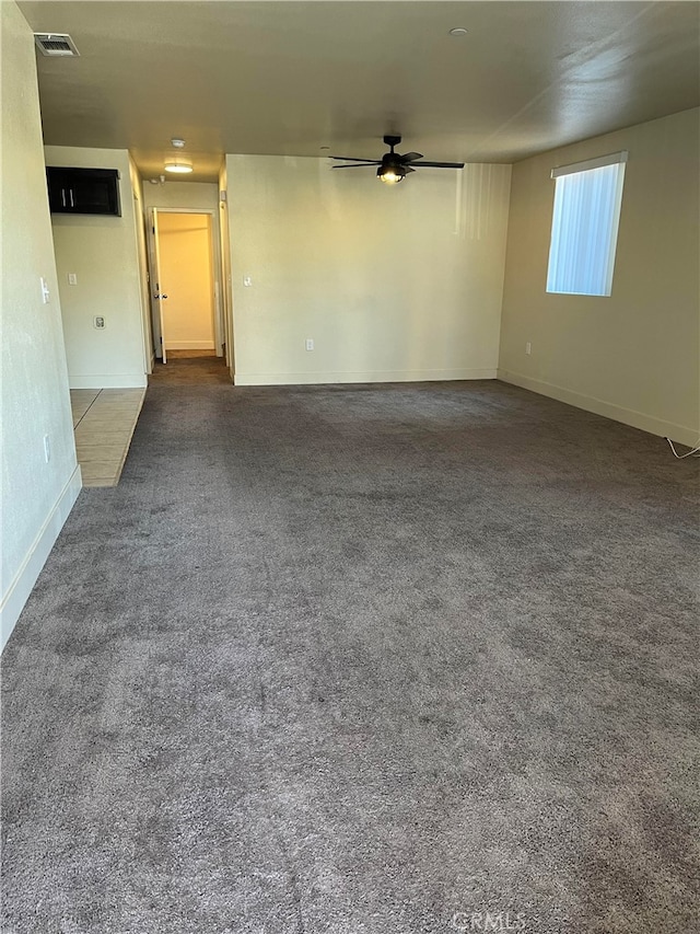 unfurnished room featuring dark carpet and ceiling fan