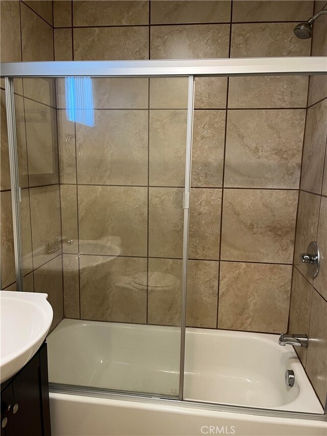 bathroom with shower / bath combination with glass door and vanity