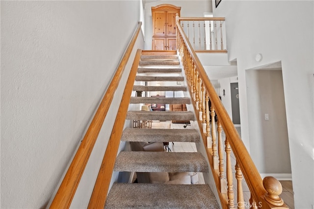 staircase featuring a high ceiling