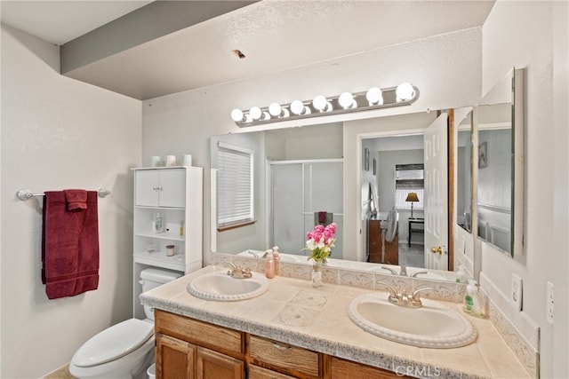 bathroom with walk in shower, vanity, and toilet