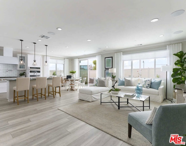 living room featuring light hardwood / wood-style flooring and crown molding