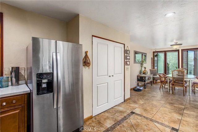 30421 Live Oak Dr, Running Springs, CA 92382 - kitchen with baseboards, brown cabinets, light countertops, and stainless steel fridge with ice dispenser